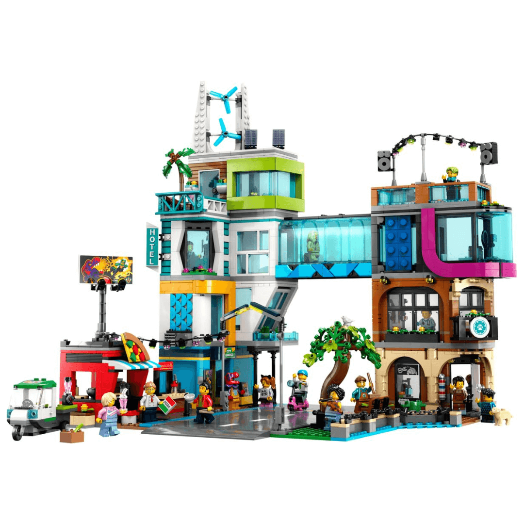 60380 Lego City Downtown Built Set. Two Buildings With A Glass Tunnel Connecting The Two. One Side Complete With 3 Storys And Open Rooftop. Other Side Complete WIth 4 Stoys, Wind Turbines And Solar Panels. At BAse Of Building A Takeaway Pizza Shop Is Seen. The Figures Included (Workers And Customers) Are Seen Doing Various Activities At The Base Of Building.