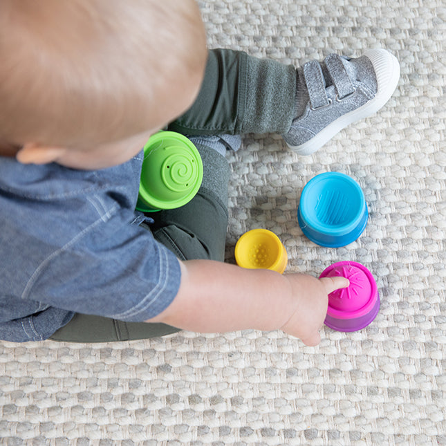 Child plays Fat Brain Toys Dimpl Stack in separate pieces 